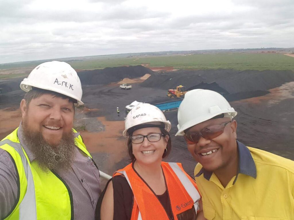 Babenakwena Mining founder with colleagues overlooking a coal stockyard